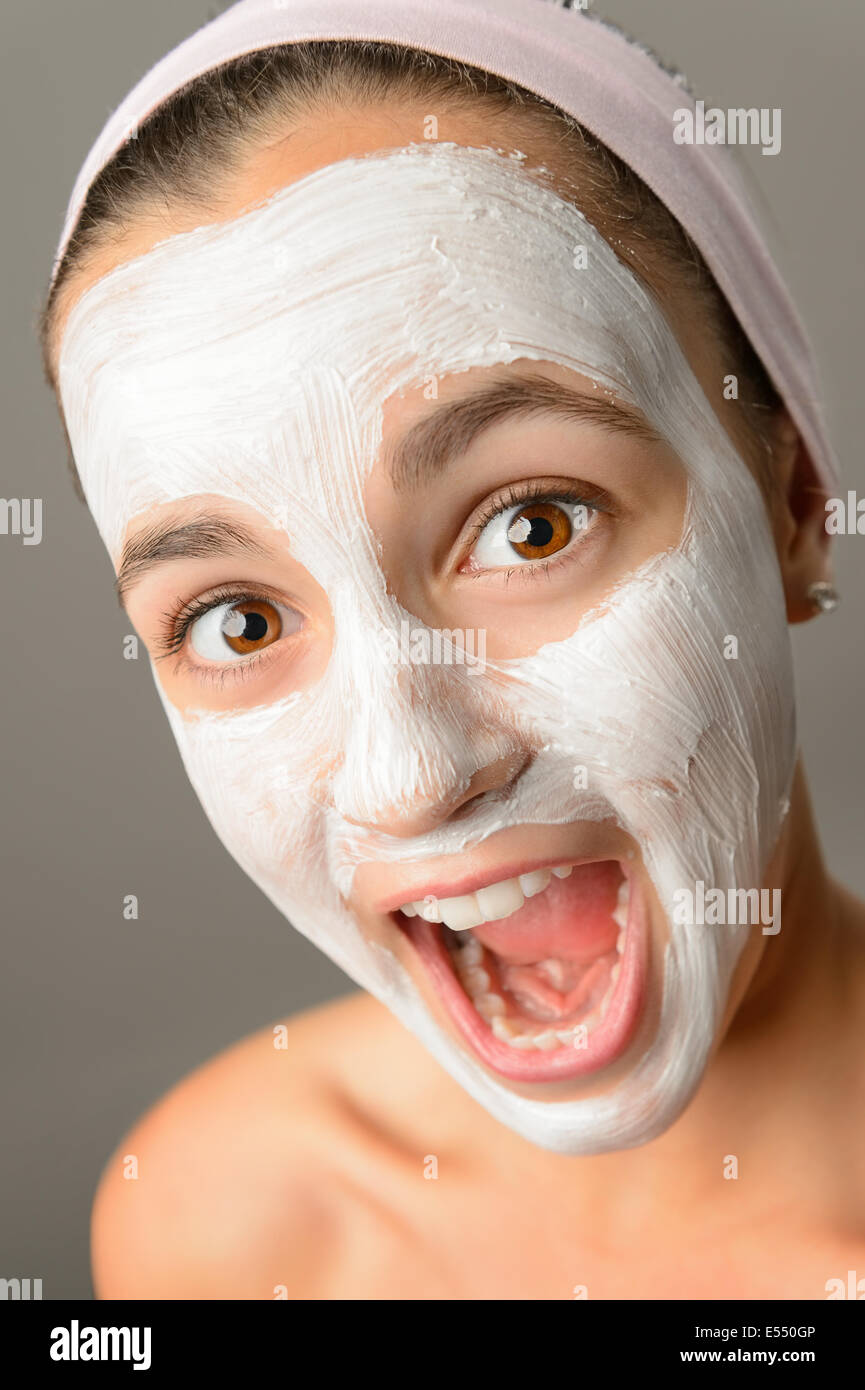 Crazy ragazza adolescente maschera facciale a bocca aperta gridando close-up guardando la fotocamera Foto Stock