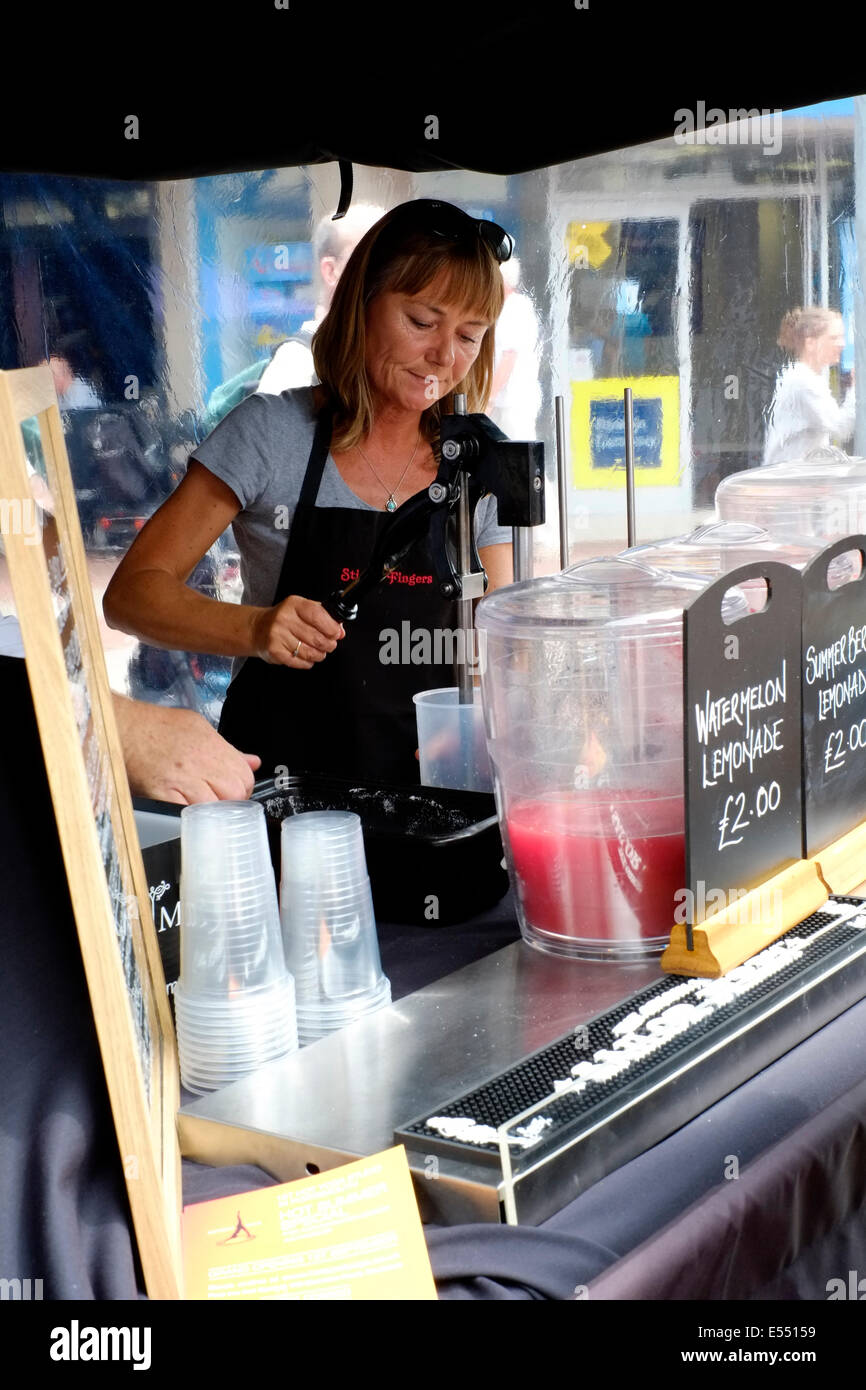 Femmina titolare di stallo miscelazione frullati di frutta e succhi di frutta a Southsea food fair festival 2014 England Regno Unito Foto Stock