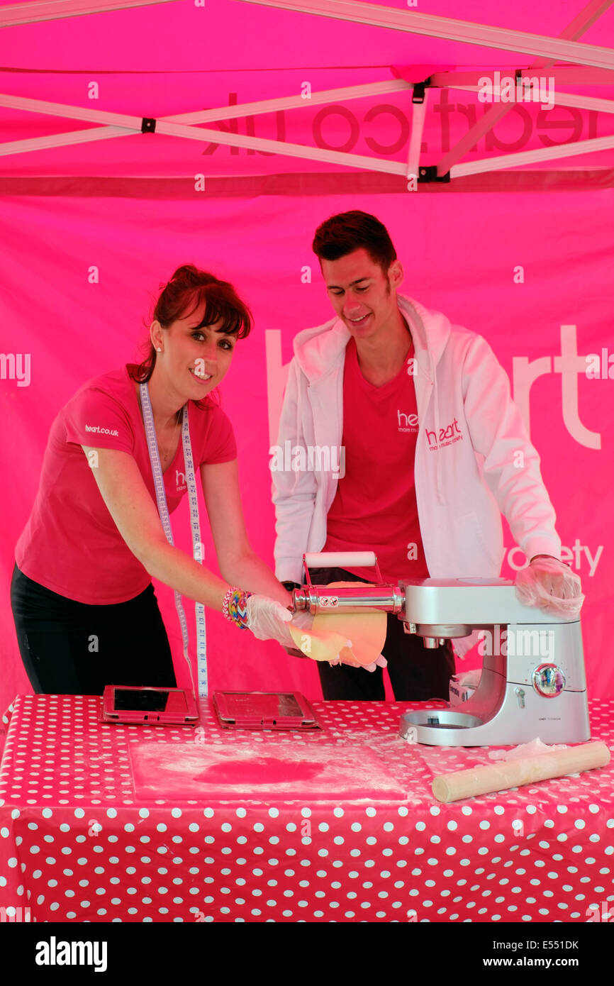 I membri dello staff a cuore stand radio dimostra la pasticceria a Southsea food fair festival 2014 England Regno Unito Foto Stock