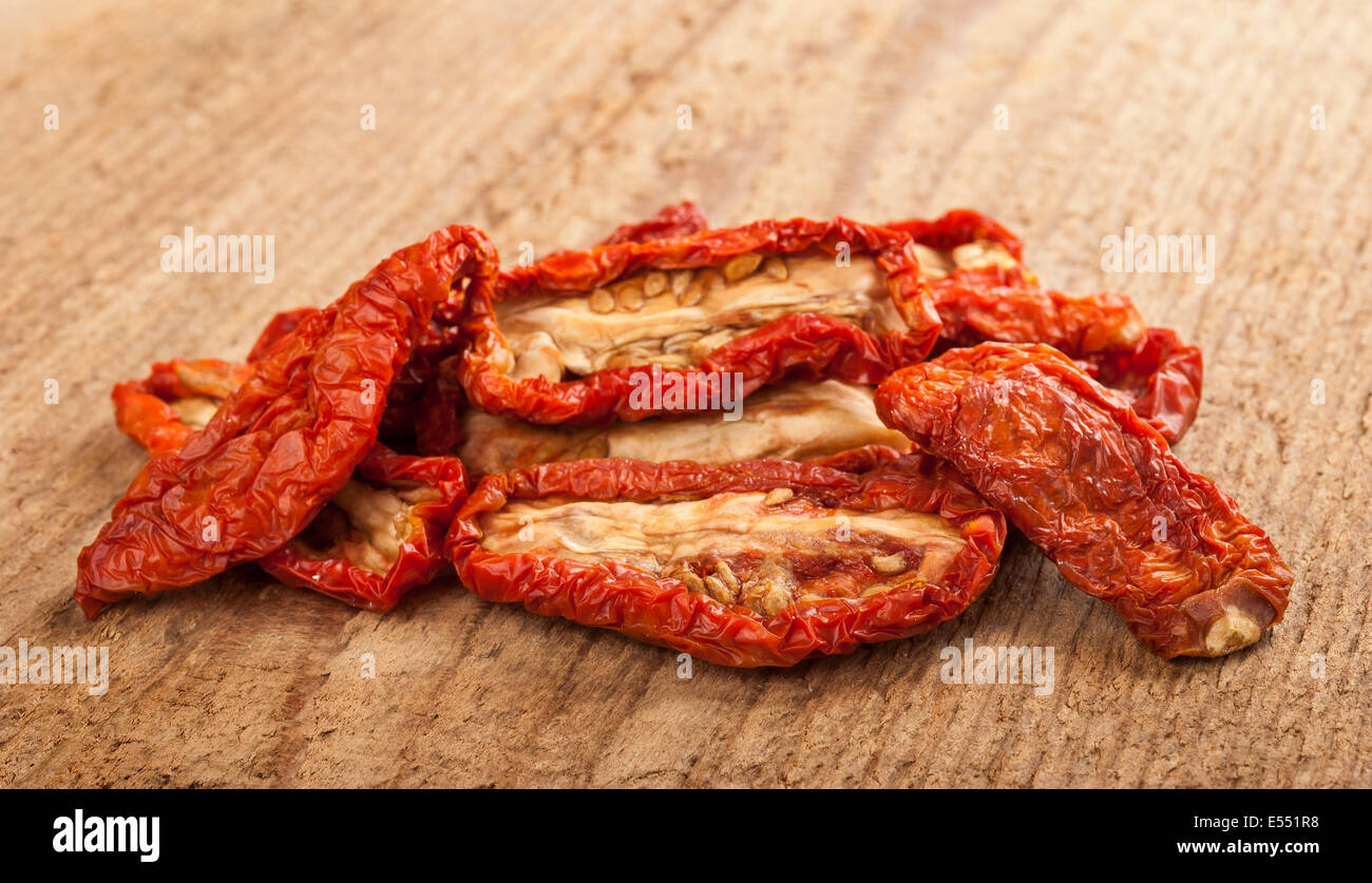 Pomodori secchi su uno sfondo di legno. Foto Stock