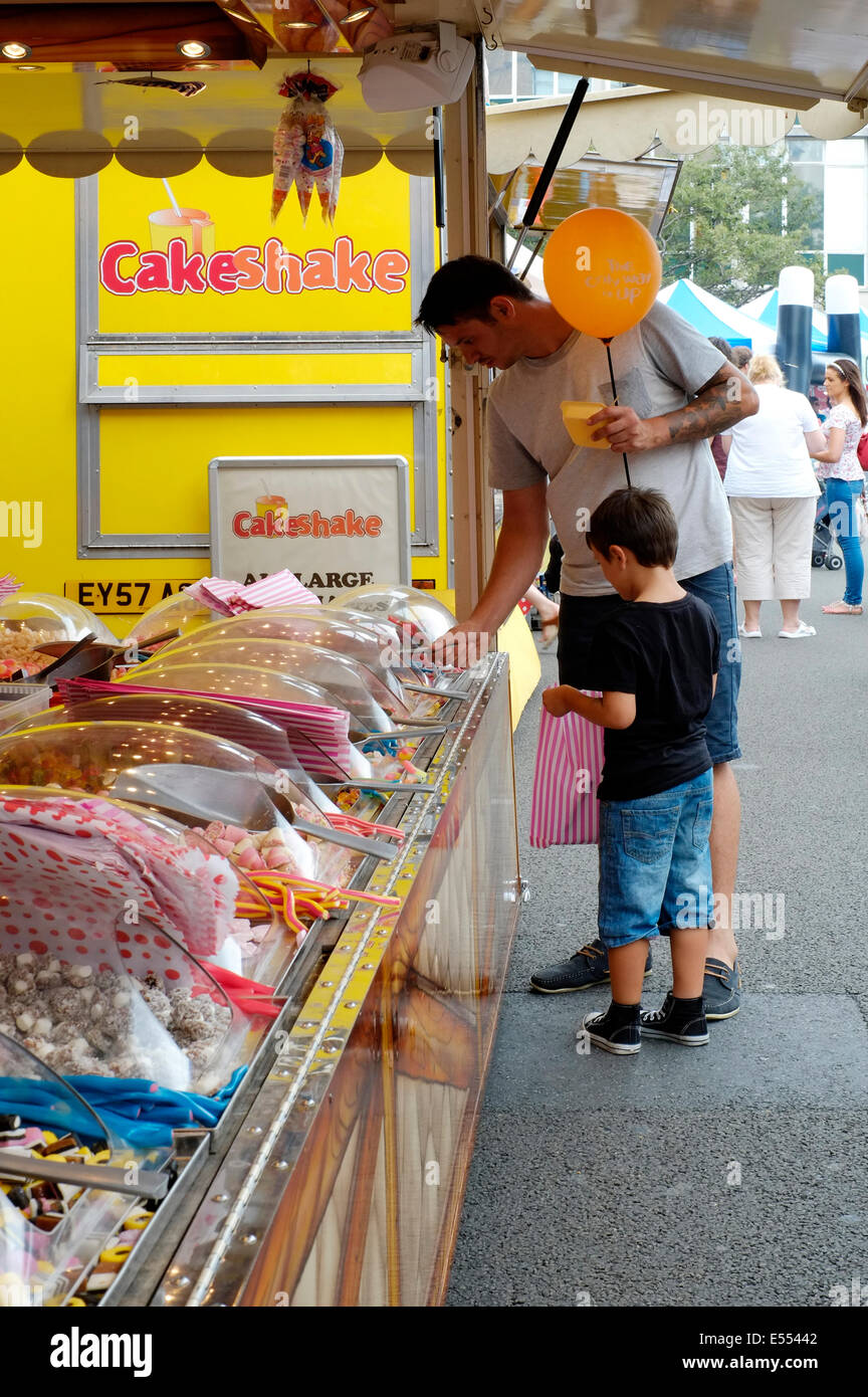 Padre e figlio giovane guardando i dolci su una fase di stallo a Southsea food fair festival 2014 England Regno Unito Foto Stock