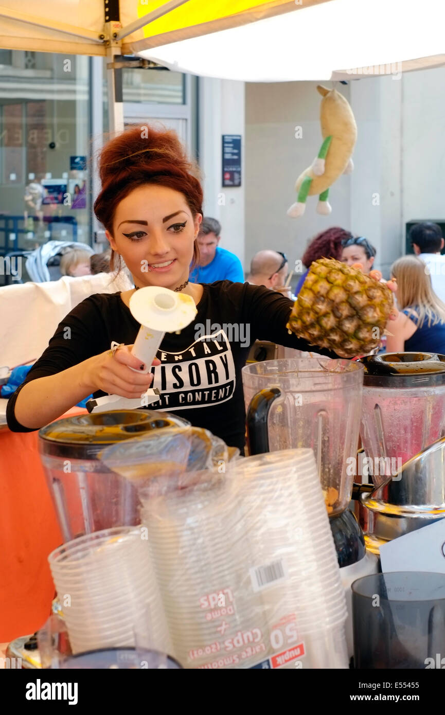 Piuttosto giovane femmina la miscelazione di frullati di frutta a Southsea food fair festival 2014 England Regno Unito Foto Stock