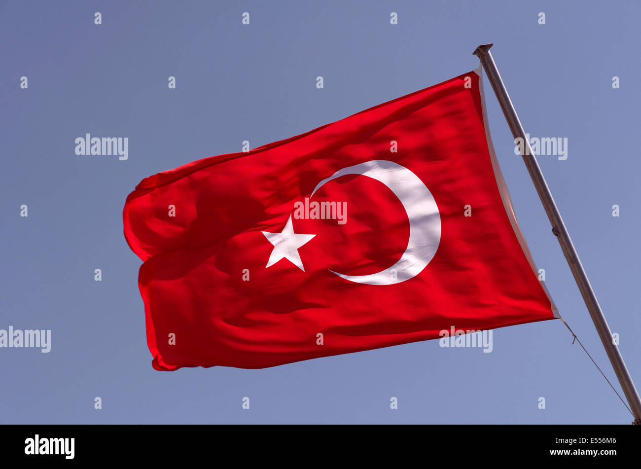 Bandiera turca con la mezzaluna e stella contro il cielo blu Foto Stock