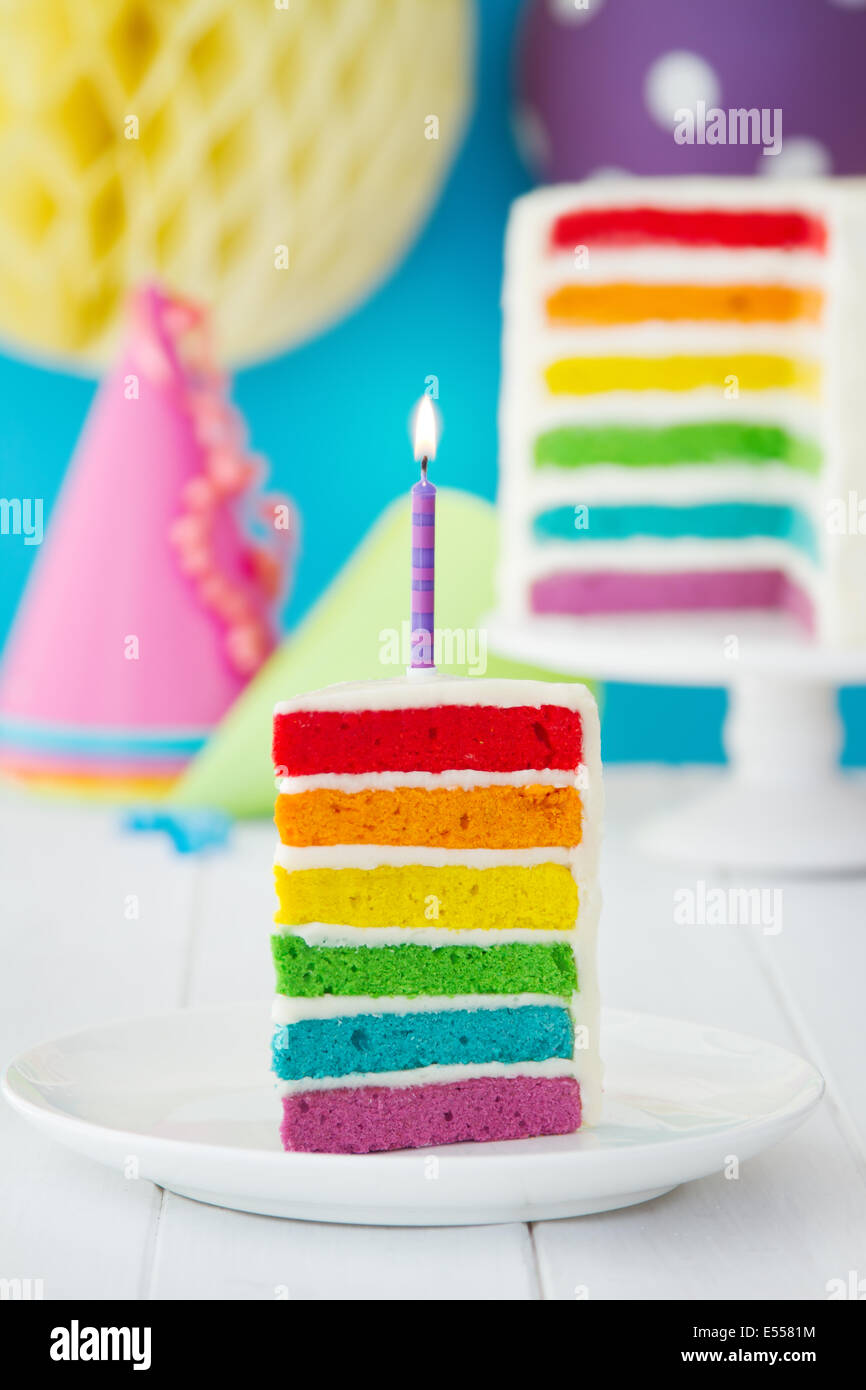 Rainbow torta decorata con una singola candela Foto Stock