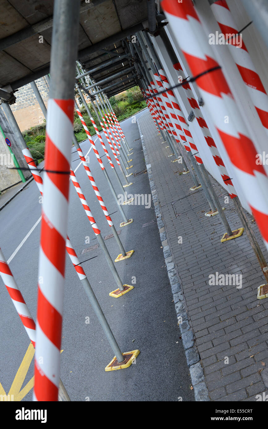 Ponteggio bloccando il marciapiede avvolto in nastro di avvertimento pericolo Foto Stock