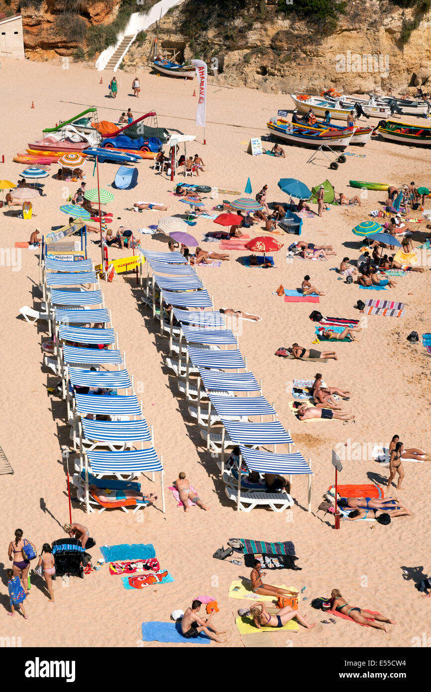 La gente a prendere il sole su una spiaggia in vacanza, Carvoeiro, Algarve, Portogallo, Europa Foto Stock