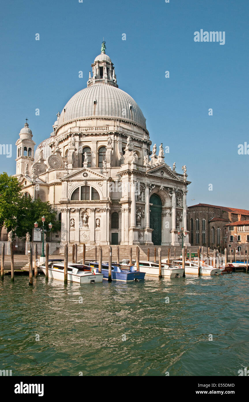 Basilica di Santa Maria della Salute vista dal Canal Grande Venezia Italia in inizio di mattina di sole con ormeggiate barche basilico Foto Stock