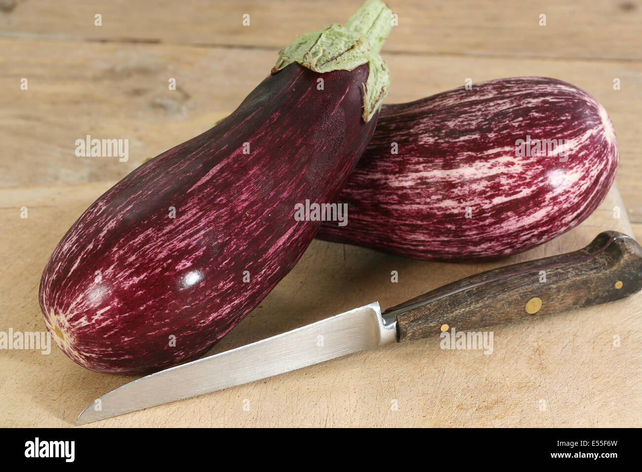 Due viola e bianco melanzane o melanzane su una tavola di legno Foto Stock