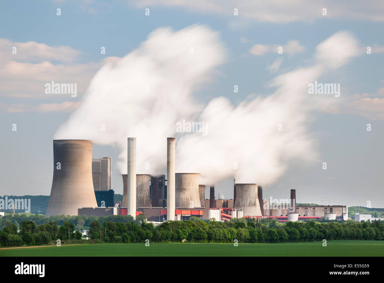 Una lunga esposizione colpo di una centrale elettrica a carbone nella distanza nel paesaggio agricolo. La stazione di potenza Niederaussem ha t Foto Stock