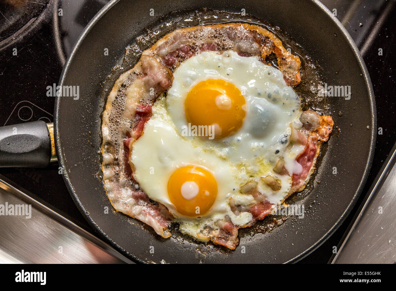Uova fritte e bacon in una padella, prima colazione, Foto Stock