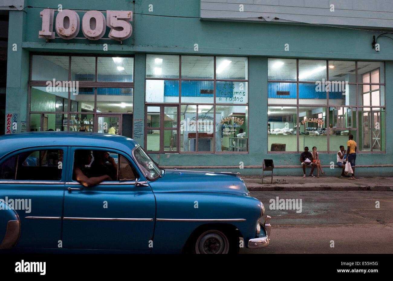 Scena di strada di Havana Cuba con la classica vettura americana e il negozio al crepuscolo. Foto Stock