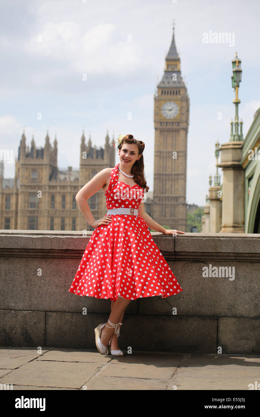 Ragazza in rosso polka dot dress in piedi nella parte anteriore del Big Ben e il Parlamento nel centro di Londra Foto Stock