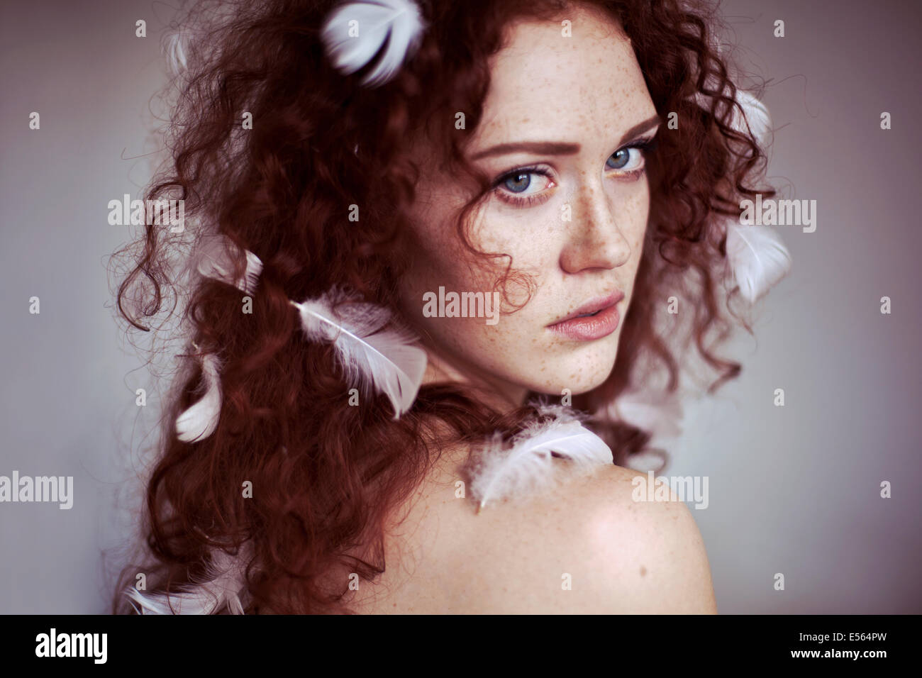Giovane donna con piume e i suoi capelli Foto Stock