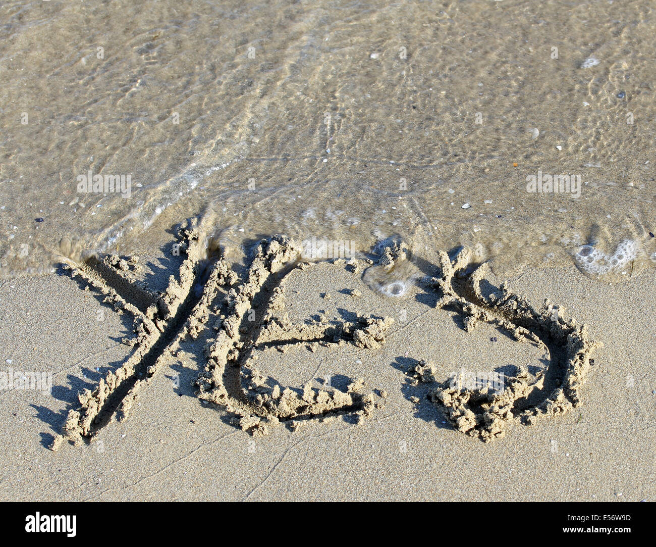 Sea Wave cancella la parola sì incisi sulla sabbia della spiaggia del Mare 1 Foto Stock