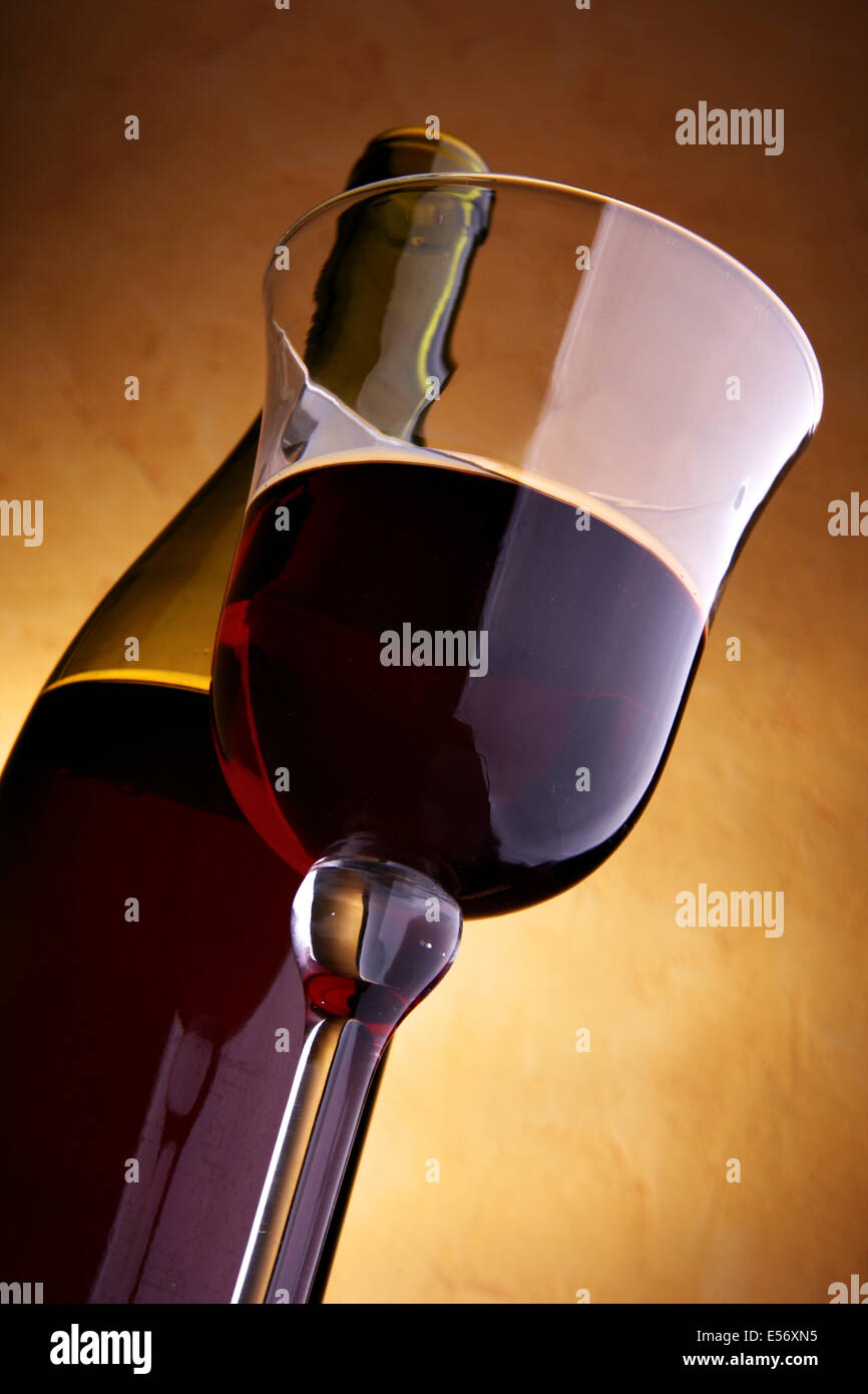 Vetro e una bottiglia di vino rosso su sfondo scuro Foto Stock