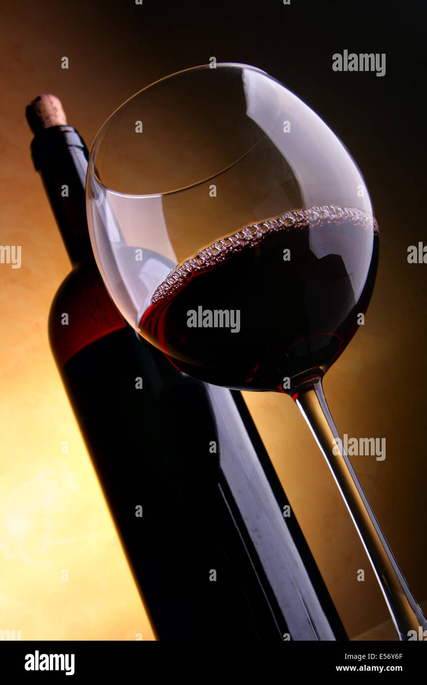 Vetro e una bottiglia di vino rosso su sfondo scuro Foto Stock