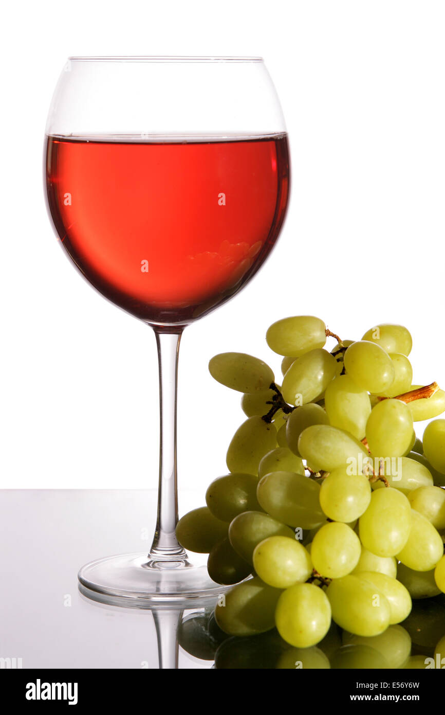 Bicchiere di vino rosso e uva isolate su sfondo bianco Foto Stock