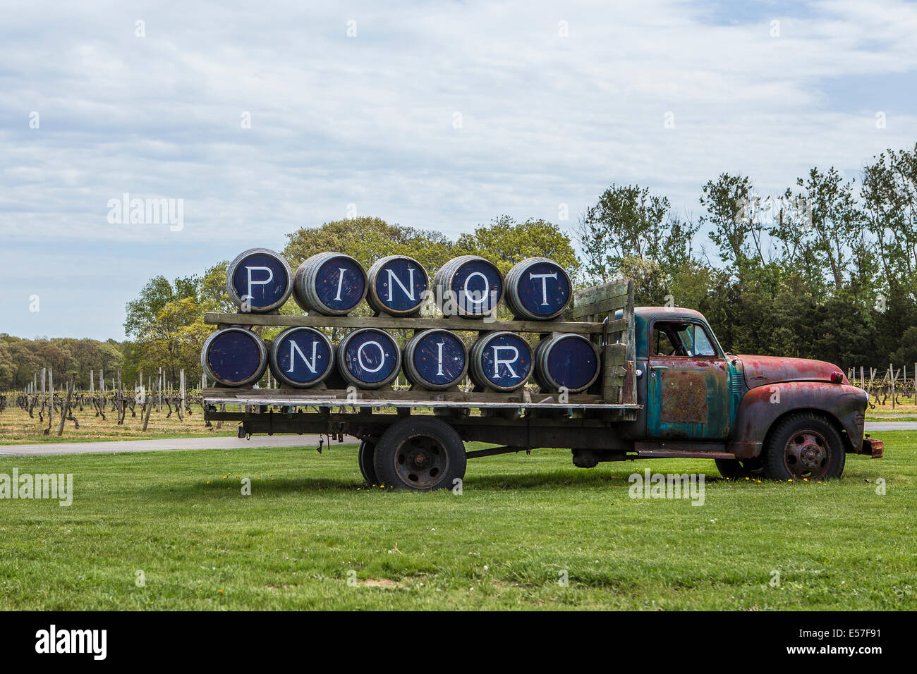 Un vecchio e arrugginito azienda carrello vino botte ortografia " Pinot noir " è vista sul Castello di Borghese in vigna Cutchogue, Nuovo Yo Foto Stock