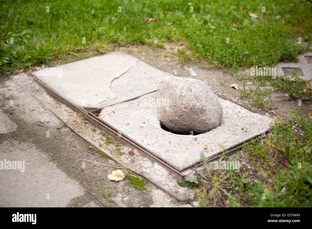 Grande pietra nel coperchio di scarico foro, pericolose frammento di pavimentazione a Varsavia, in Polonia, in orientamento orizzontale, nessuno. Foto Stock