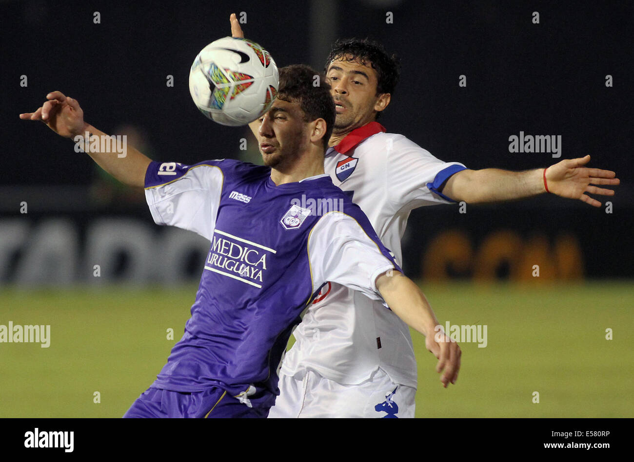 Asuncion in Paraguay. 22 Luglio, 2014. Julian Benitez (indietro) del Paraguay di Nacional sistema VIES per la palla con Enrique Echeverri dell Uruguay il Defensor Sporting durante la prima tappa della Coppa Libertadores semifinali in Asuncion in Paraguay, il 22 luglio 2014. © Marcelo Espinosa/Xinhua/Alamy Live News Foto Stock