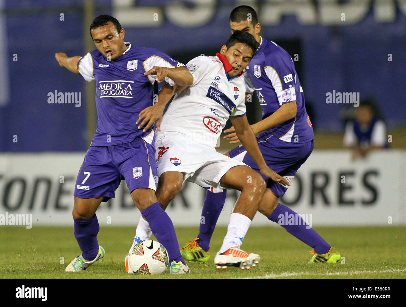 Asuncion in Paraguay. 22 Luglio, 2014. Silvio Torales (C) del Paraguay di Nacional sistema VIES per la palla con Juan Carlos Amado (L) dell'Uruguay Defensor Sporting durante la prima tappa della Coppa Libertadores semifinali in Asuncion in Paraguay, il 22 luglio 2014. © Marcelo Espinosa/Xinhua/Alamy Live News Foto Stock