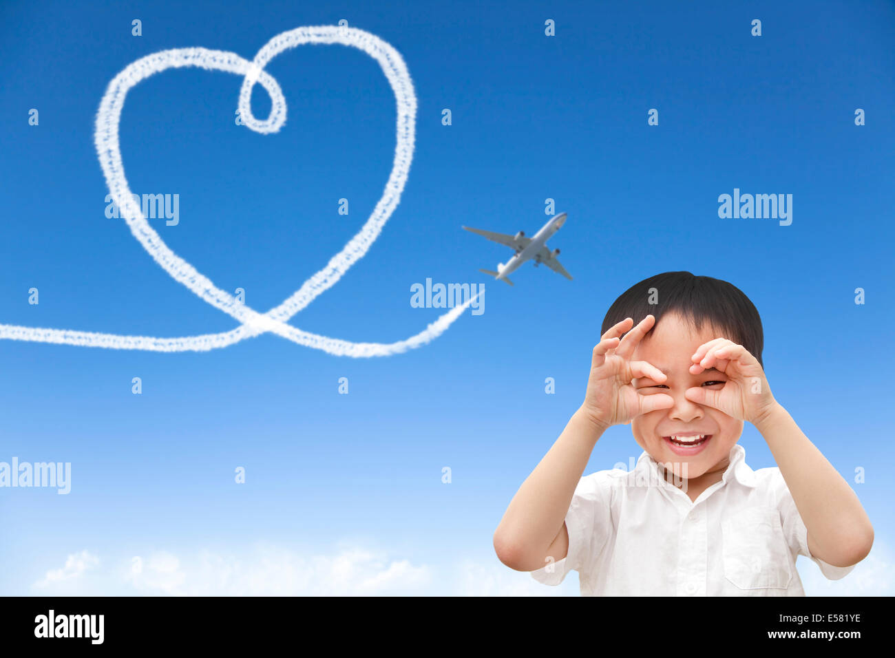 Felice ragazzo la visione di aereo e il disegno di un cuore del cloud Foto Stock