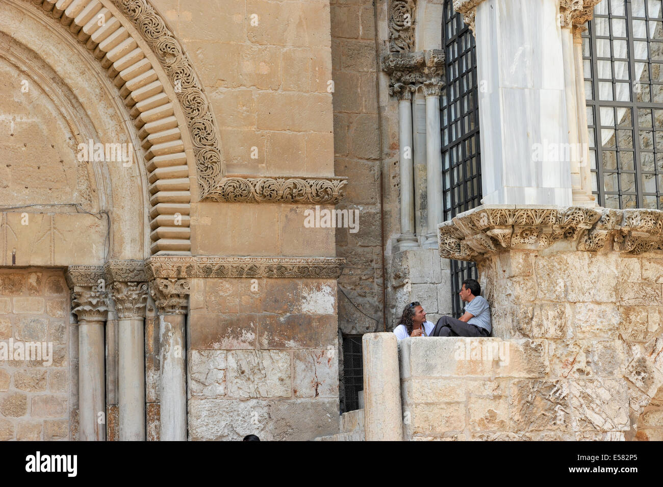 Due pellegrini sedersi fuori, la Chiesa del Santo Sepolcro di Gerusalemme, Israele Foto Stock