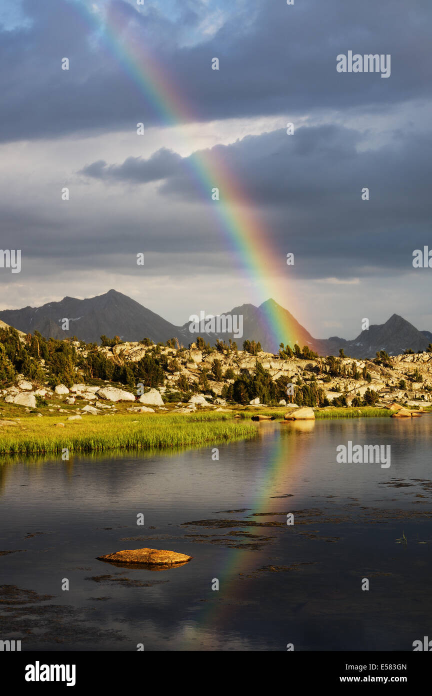 Rainbow si riflette in un deserto lago nelle montagne della Sierra Nevada della California Foto Stock