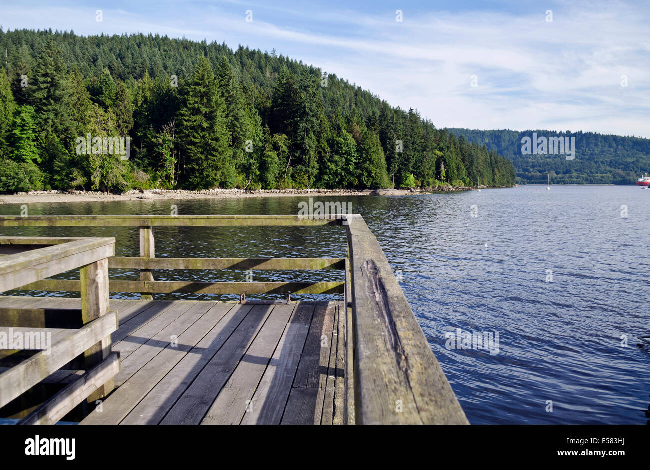 Il molo di legno che si affaccia su acque di Burrard ingresso e foresta di Belcarra Parco Regionale in maggiore di Vancouver. Foto Stock
