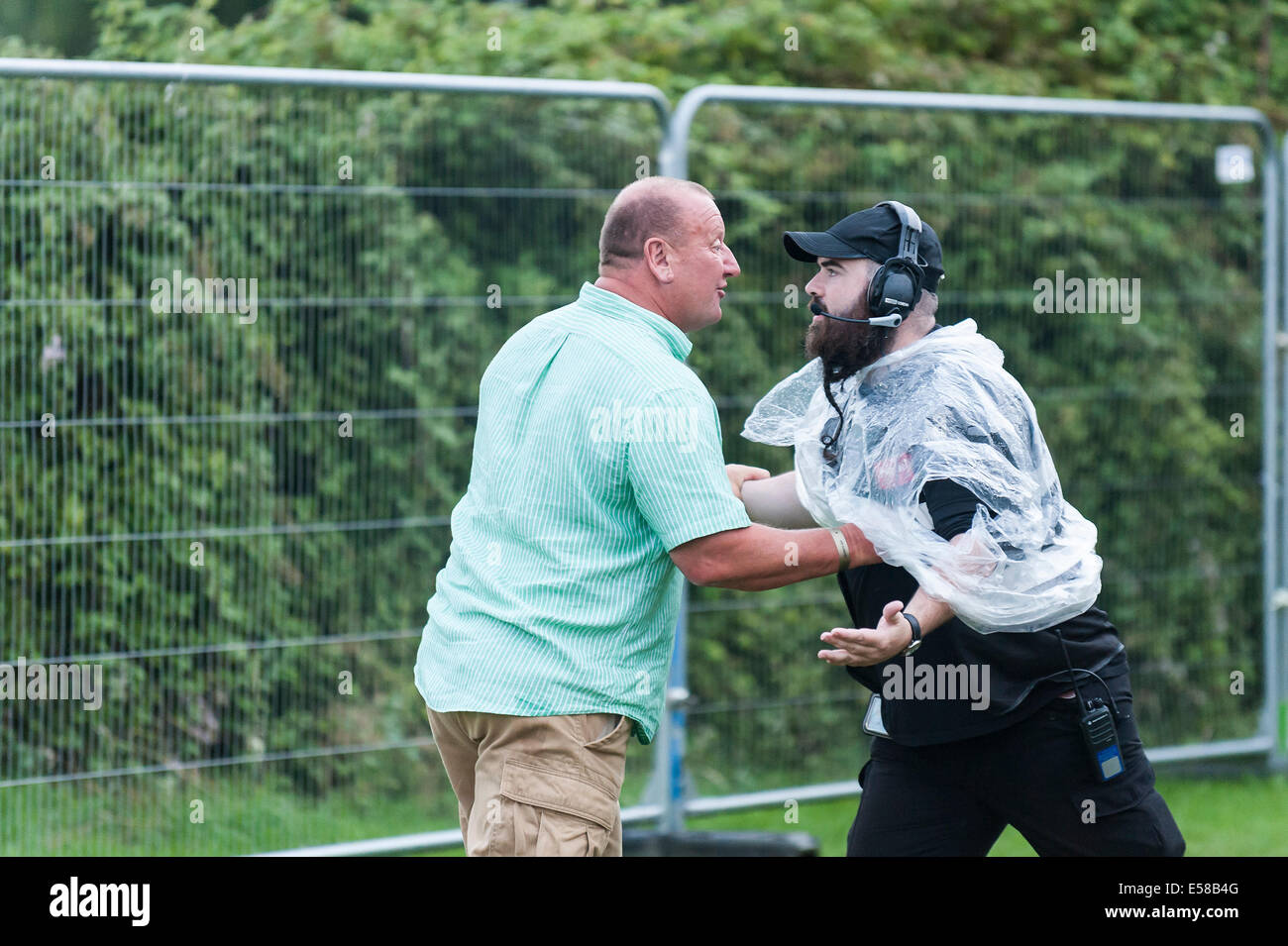 Un confronto tra una guardia di sicurezza che ferma un membro del pubblico. Foto Stock