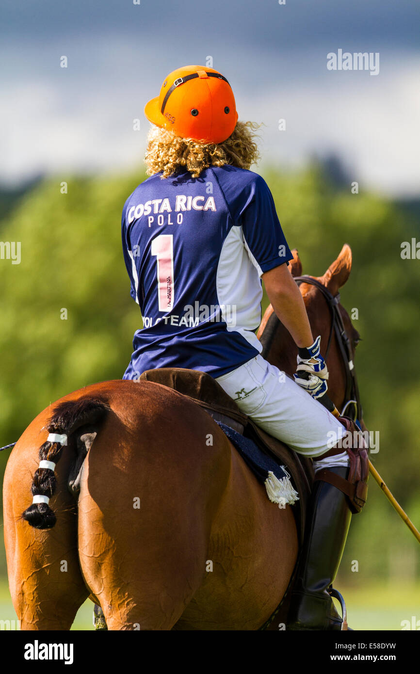 Flamboyant, vivid maglietta e casco colori del Costa Rica Polo team nel sole del tardo pomeriggio. Foto Stock