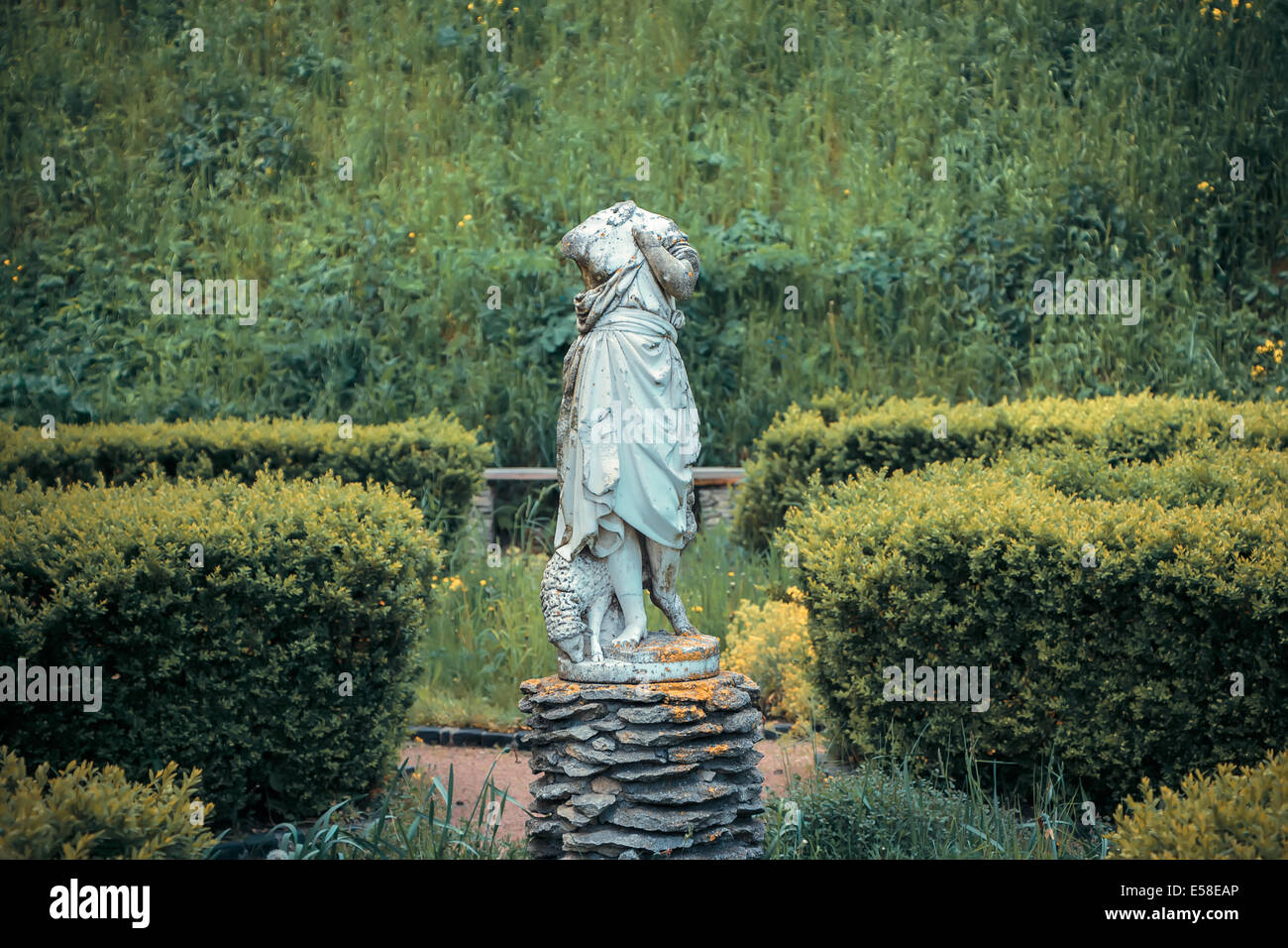 Decapitati statua di con una pecora in giardino Foto Stock