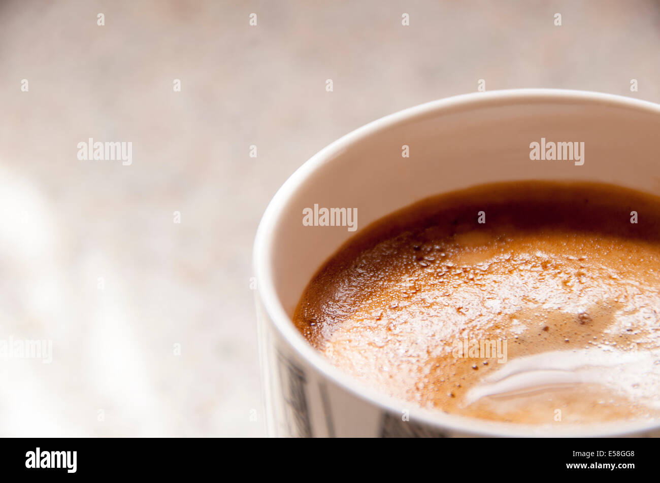 Una tazza di caffè appena fatto in una tazza alta sul lato della cucina Foto Stock