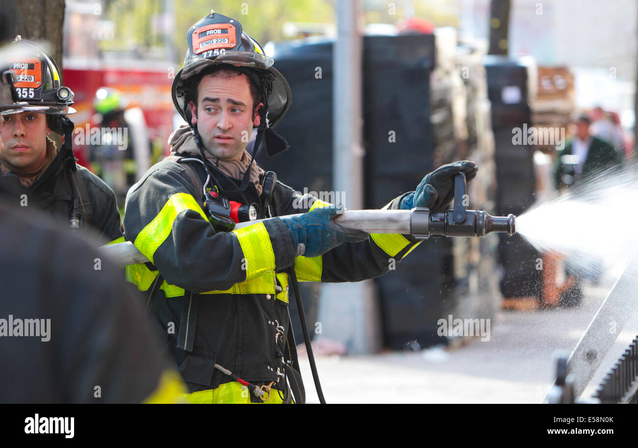 New York City - FDNY vigili del fuoco spruzzare acqua sul fuoco residenziale nel quartiere di Gowanus di Brooklyn Foto Stock