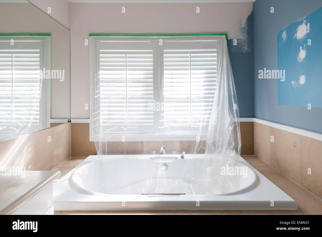 Home rinnovamento di mirroring di bagno con grande vasca e mattonelle in pietra Foto Stock