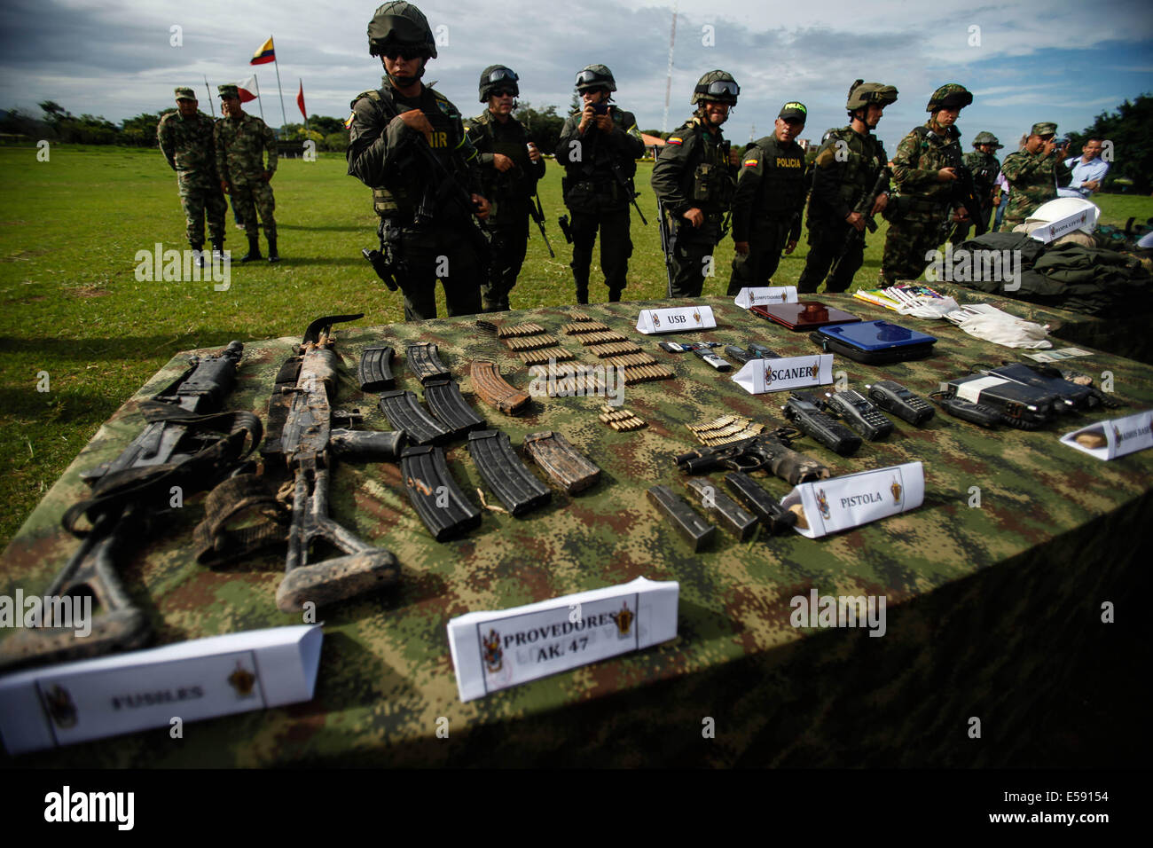 Arauca, Colombia. 23 Luglio, 2014. Guardia di soldati sequestrati armi e oggetti dei membri dell'Esercito di Liberazione Nazionale (ELN) dopo un intervento di forze militari nelle aree rurali sono di Fortul comune, Dipartimento di Arauca, Colombia, il 23 luglio 2014. Colombia il Ministero della Difesa ha detto Mercoledì la forze armate ucciso 13 ribelli di sinistra e catturato otto in due operazioni distinte. Foto Stock