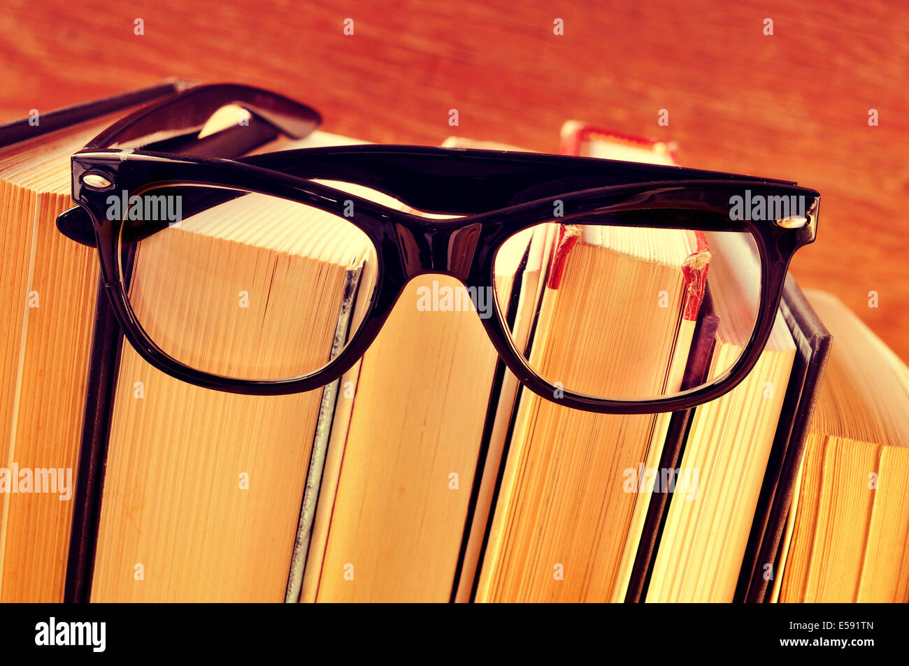 Un paio di occhiali su una pila di libri con un effetto retrò Foto Stock