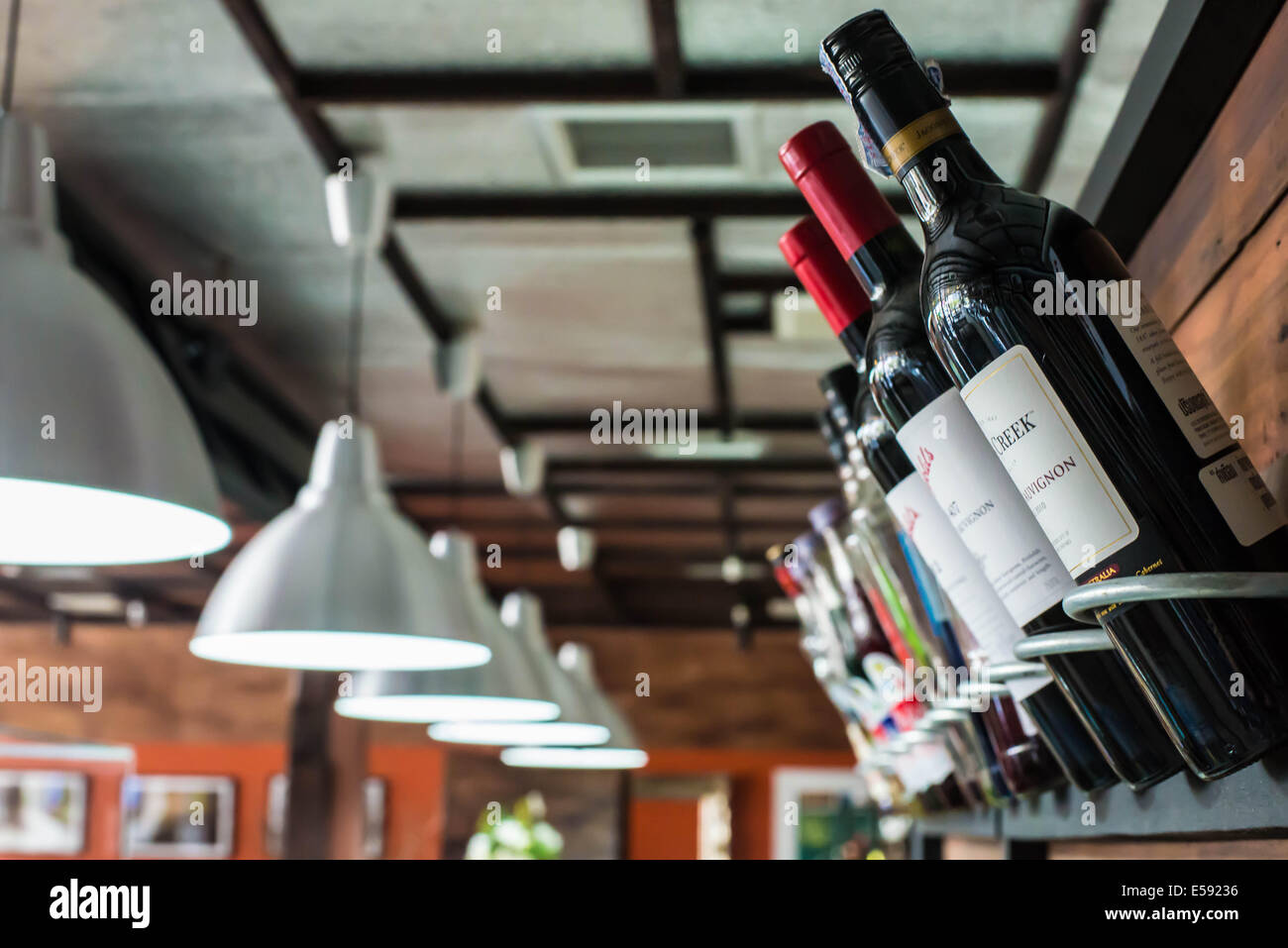 Tre bottiglie di vino su scaffalature di legno in un ristorante. Foto Stock