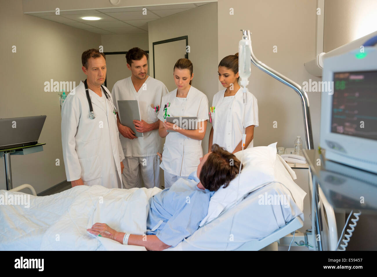Il team medico frequentando paziente femmina sul letto di ospedale Foto Stock