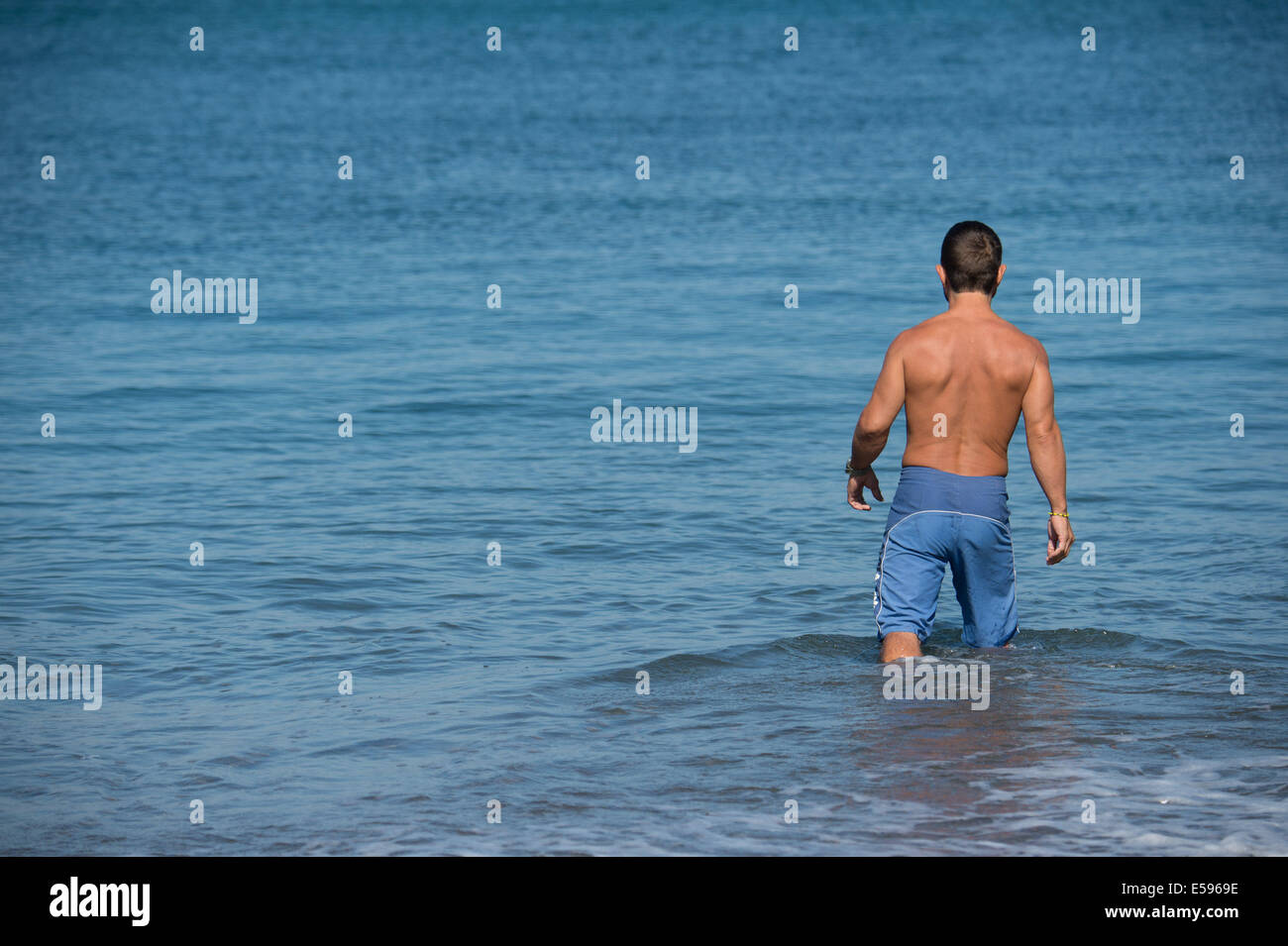 Aberystwyth, Wales, Regno Unito. Il 24 luglio, 2014. Un uomo passa per un wearly nuotata mattutina, sfruttando al massimo il caldo clima soleggiato a Aberystwyth sulla West Wales coast UK. L'ondata di caldo è previsto per una durata di almeno un altro giorno, con temperature di progetto quasi raggiungere 30c in alcuni luoghi terrestri, prima dello scambiatore meteo restituisce al weekend Photo credit: keith morris/Alamy Live News Foto Stock