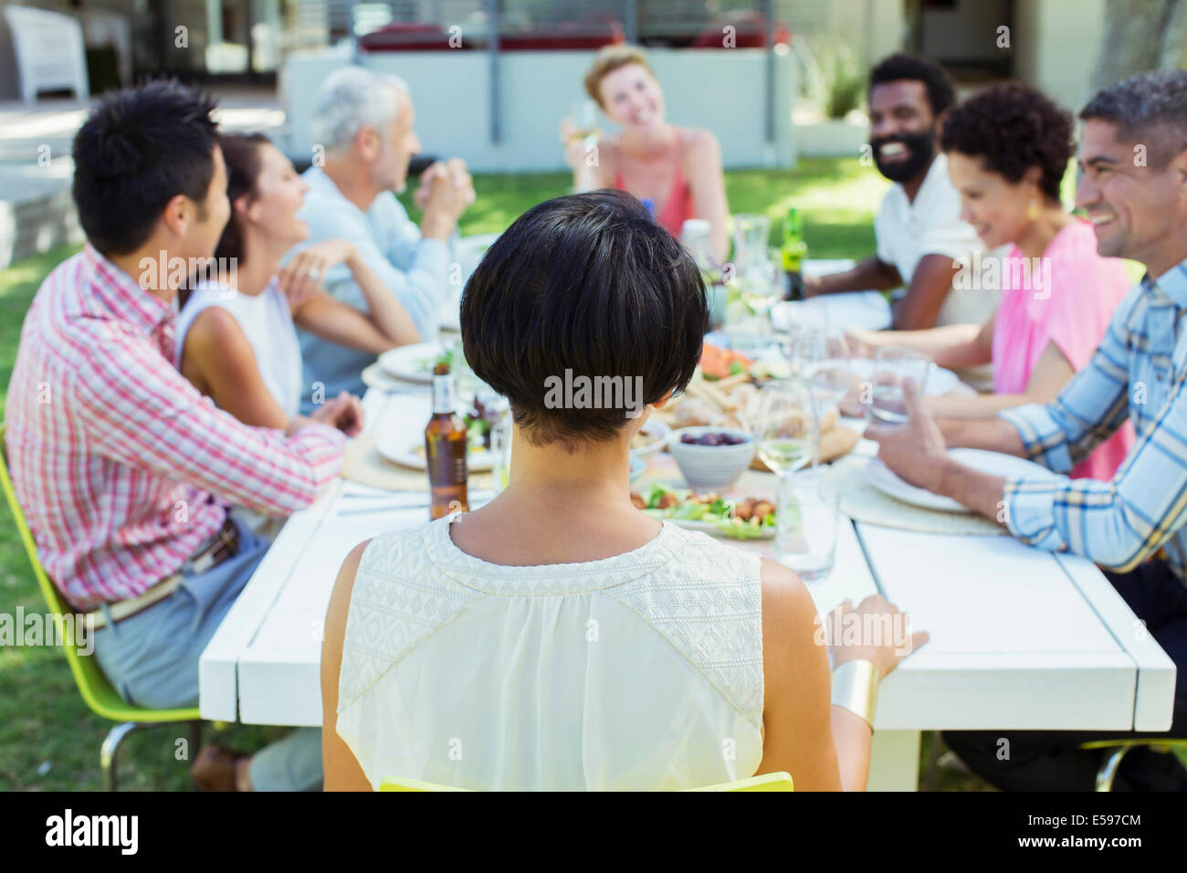 Gli amici di parlare a tavola all'aperto Foto Stock