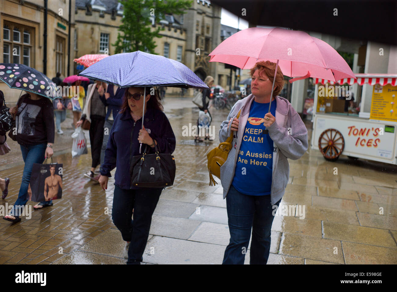 Cambridge, Inghilterra, Regno Unito. Luglio 2014 i visitatori alla città universitaria di Cambridge sotto la pioggia durante l estate britannica. Foto Stock