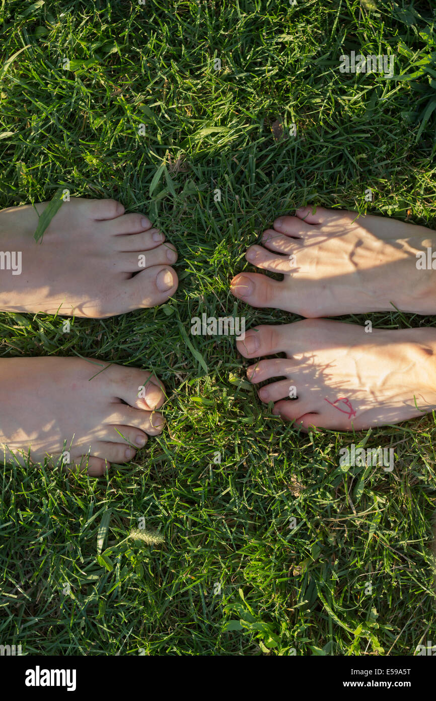 Matura in piedi l'erba con i piedi gli uni di fronte agli altri, a piedi nudi. Punto di vista personale. Foto Stock