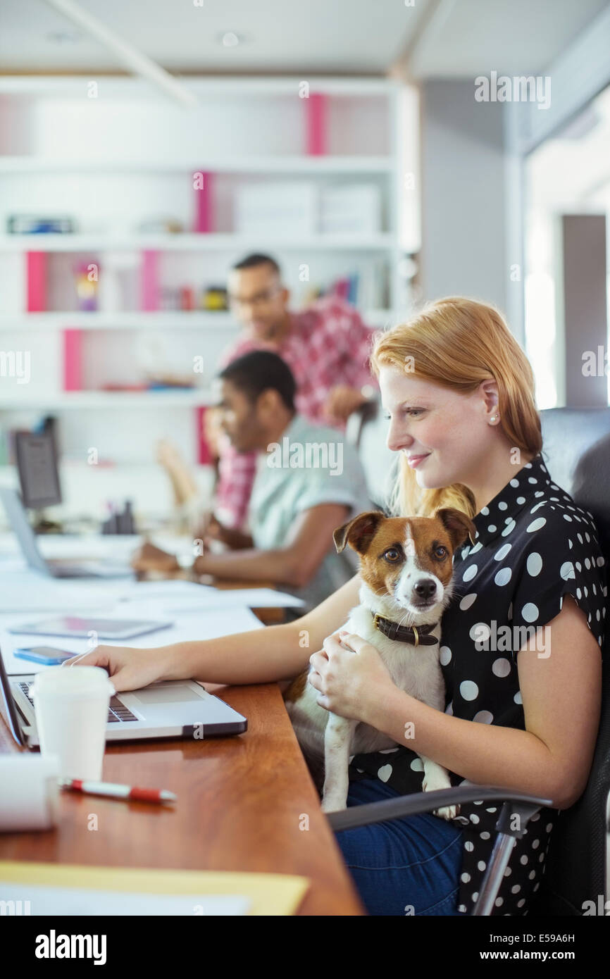 Dog sitter su donna di giro in ufficio Foto Stock