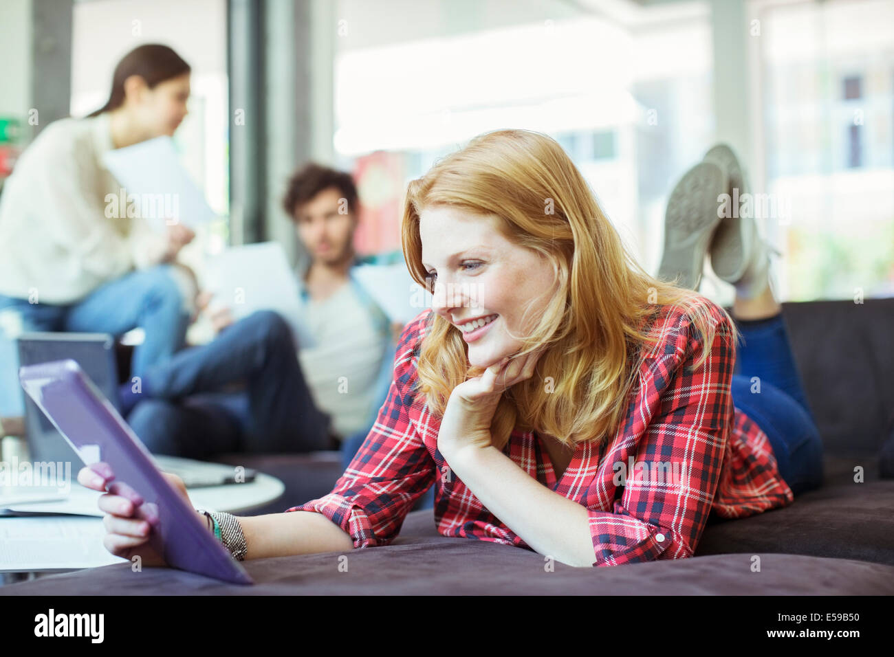 Persone che utilizzano la tavoletta digitale in ufficio Foto Stock