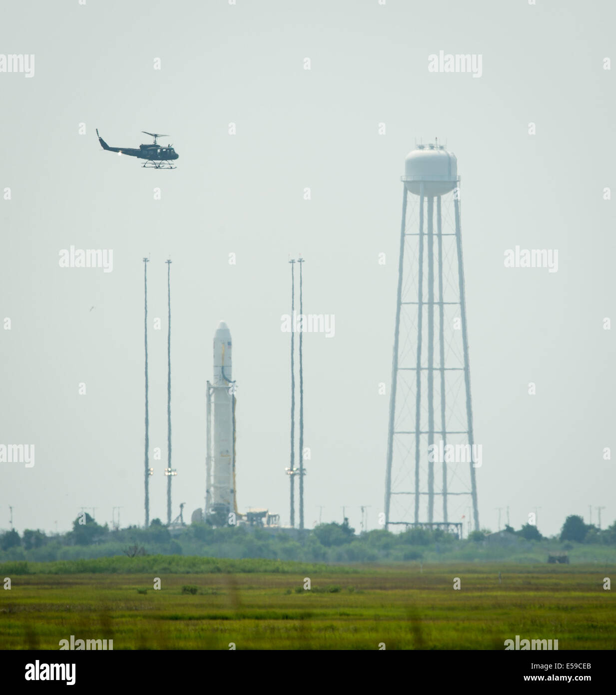 Una cauzione hlicopter vola dalla Orbital Sciences Corporation Antares rocket, 17 minuti prima del lancio, Domenica, 13 luglio 2014, alla NASA Wallops Flight Facility in Virginia. Il Cygnus lander è riempito con oltre 3.000 libbre di forniture per l'Inter Foto Stock