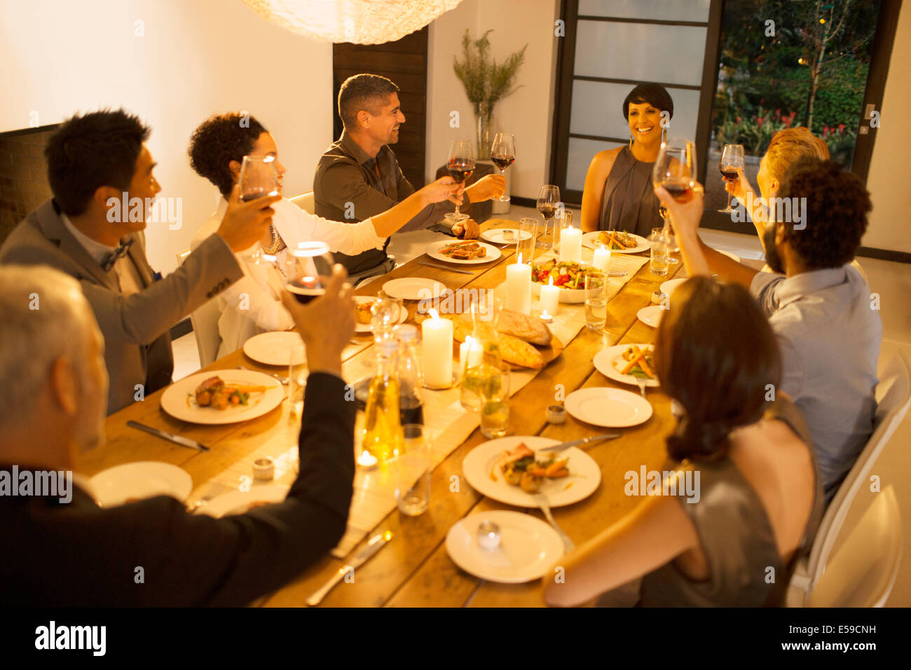 Amici tostare ogni altro a cena Foto Stock