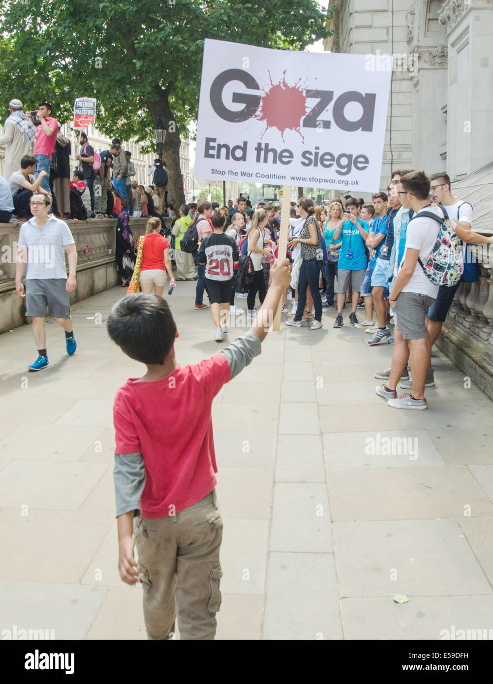 Un giovane manifestante detiene una targhetta a sostegno di porre fine all'assedio dei palestinesi di Gaza in Whitehall,Londra il 19 luglio Foto Stock