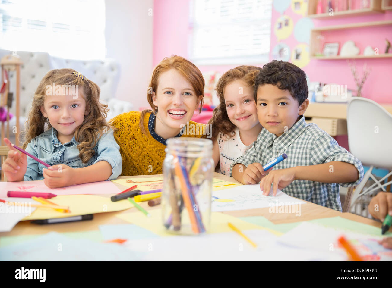 Gli studenti e il maestro sorridente in aula Foto Stock