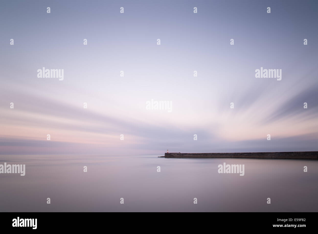 Incredibile lunga esposizione paesaggio faro al tramonto con mare calmo Foto Stock